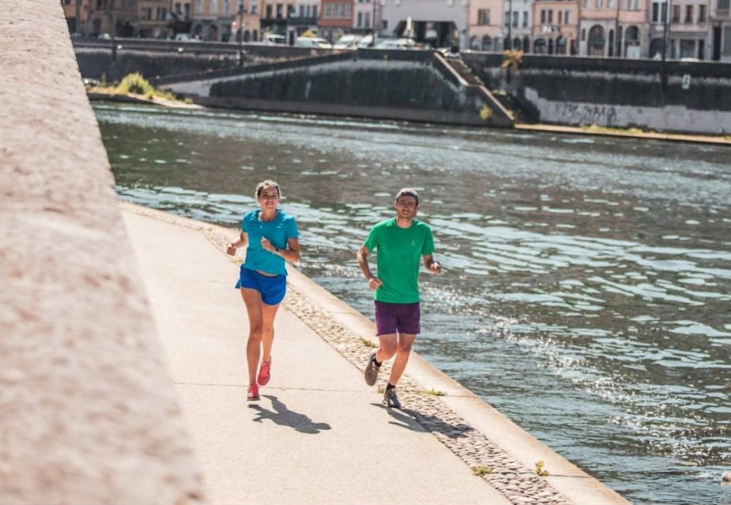 runner che corrono allenamento a sensazione in riva a un fiume